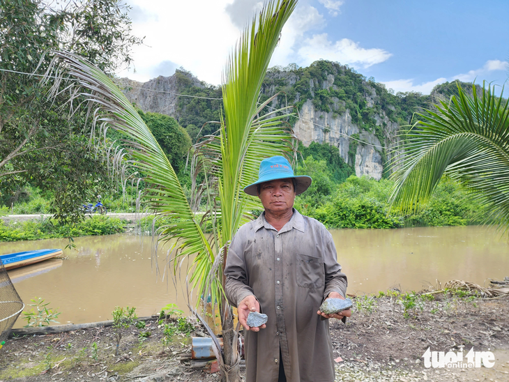Ông Lâm Văn Tâm cầm trên tay 2 cục đá, "tố" nhà máy Insee đã nổ mìn làm văng 2 cục đá vào nhà ông cách nay 7 ngày - Ảnh: BỬU ĐẤU